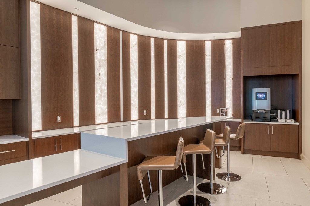 a lobby with a counter and chairs and a television